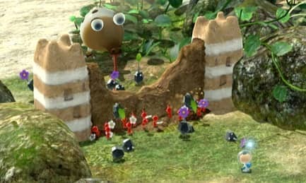 A picture of a group of Pikmin working together to break through a sand wall.
